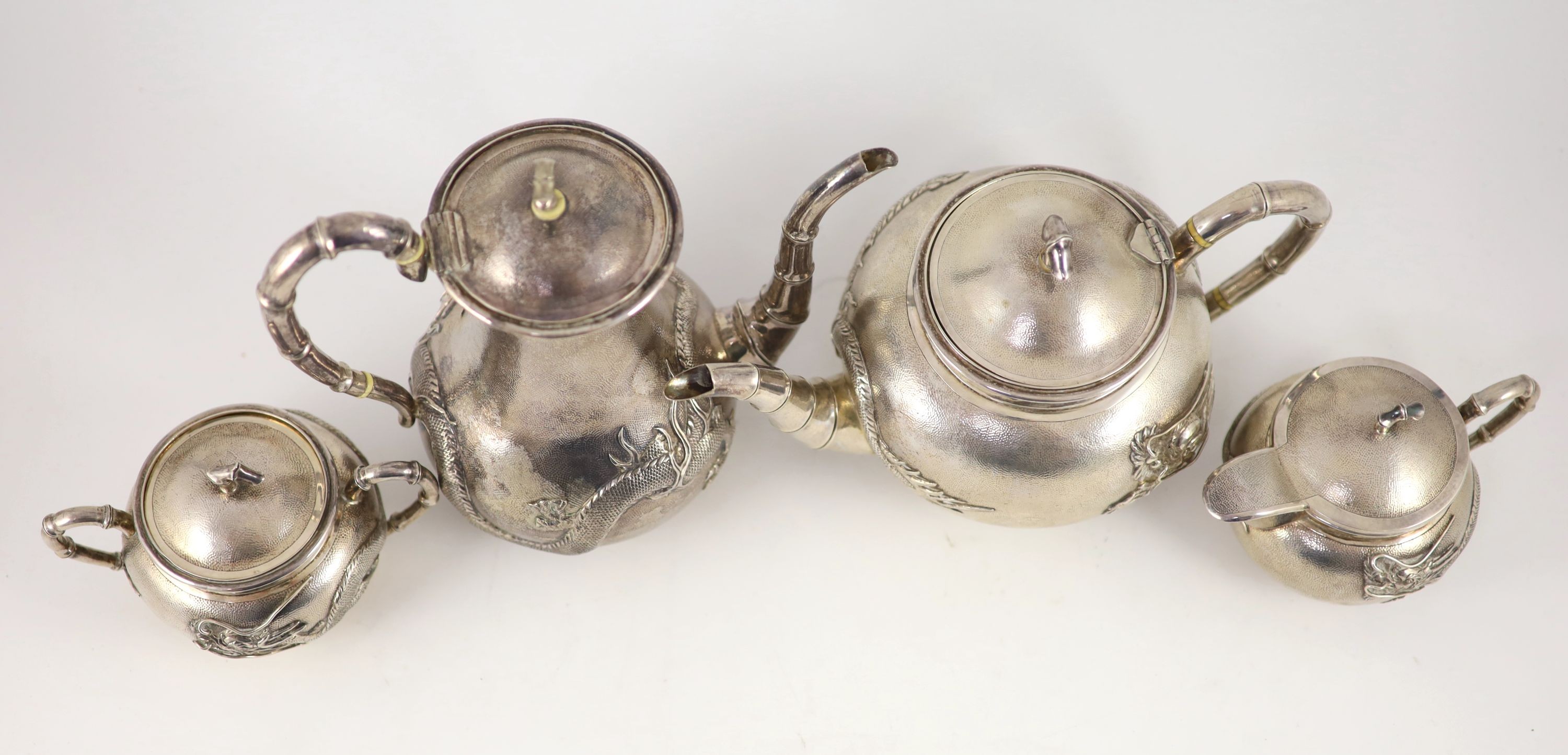 A matched early 20th century Chinese four piece planished silver tea and coffee set, cream and sugar by Wang Hing, teapot by Tack Hing and coffee pot apparently unmarked